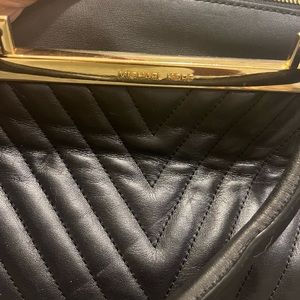 Authentic Michael Kors, leather and gold pocketbook with a Crossbody chain.